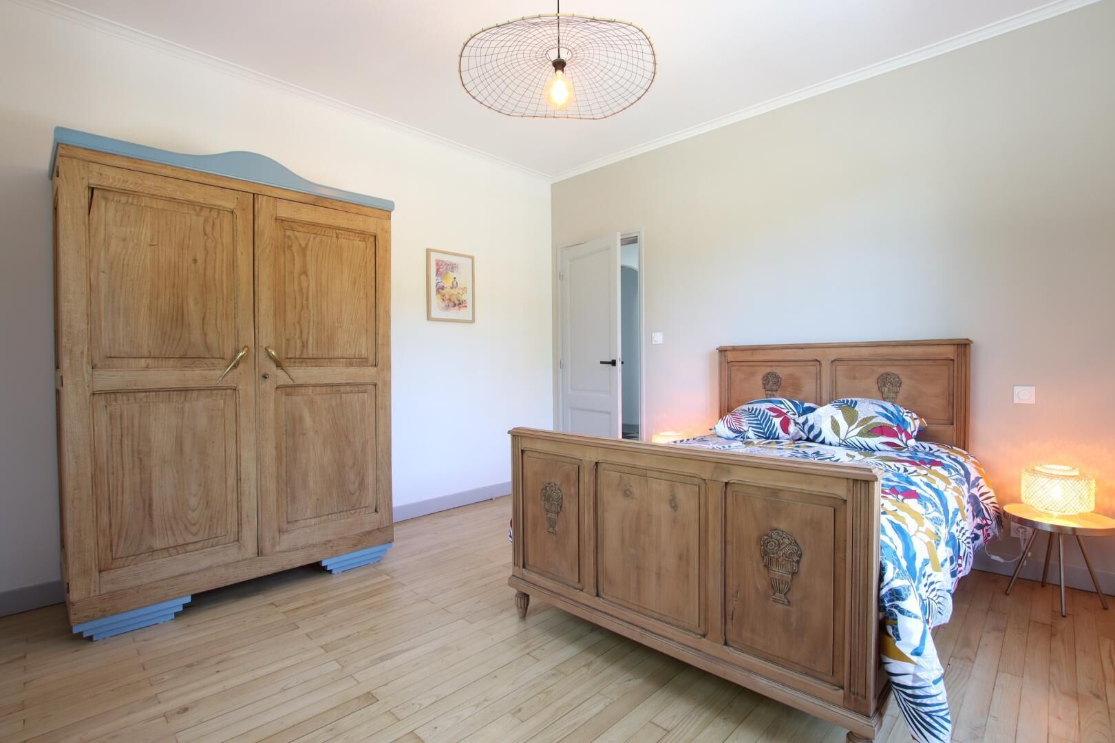 A bedroom with a wooden bed, a wardrobe, and a bedside lamp.