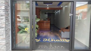 The entrance of Hotel Burj Khalifa Marmani with a reception desk and seating area visible. - HOTEL BURJ KHALIFA (Santa Ana)