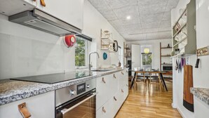 Una cocina moderna con horno empotrado, electrodomésticos de acero inoxidable y encimera de granito.