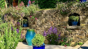 A stone wall with flower boxes and potted plants. - "Azur Blue" Villa - Rural Peace with private pool (Peymeinade)
