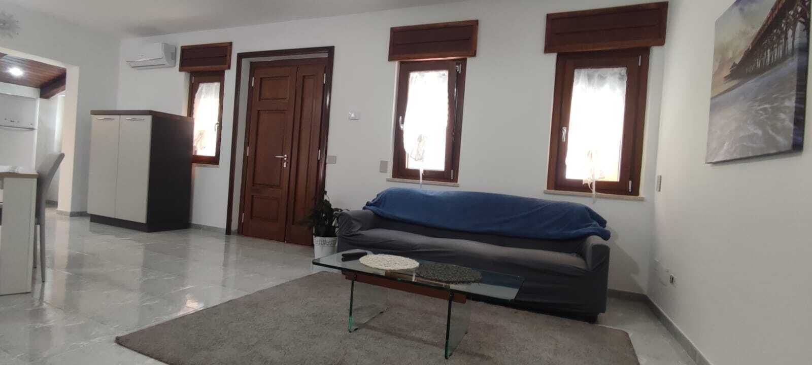 Ein Wohnzimmer mit einer Couch, einem Couchtisch und einer Tür.