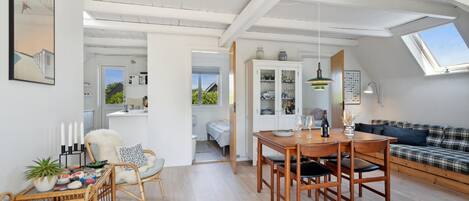 Un espacio habitable amplio con una mesa de comedor, un sofá y vistas a la cocina.
