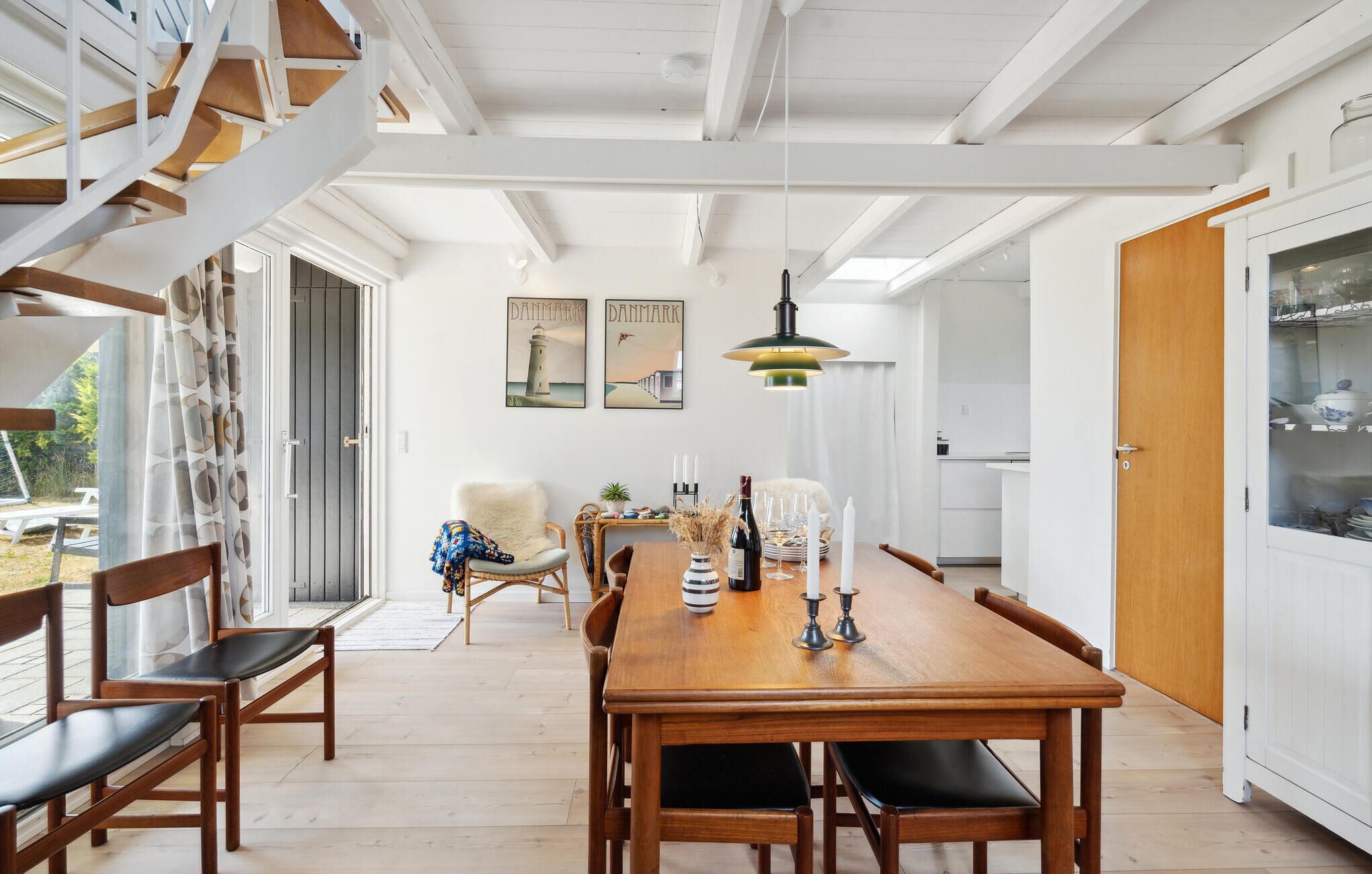 Comedor con una mesa de madera, sillas y una lámpara colgante.