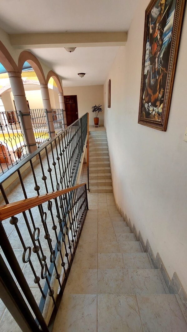 A staircase with a metal railing, leading to an upper floor. - HOTEL MORADA DE LOS ANGELES (Calera)