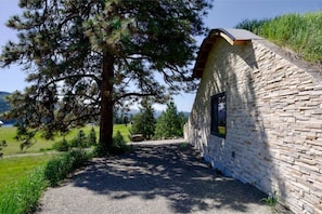 Situated in a lush landscape, this charming building features a small window and a sloped roof.