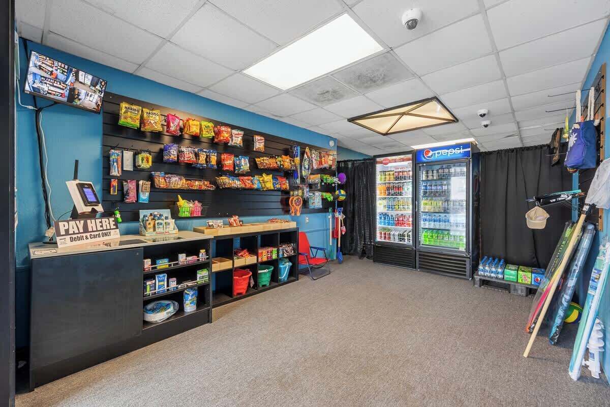 Eine Snackbar mit einem Pepsi-Kühlschrank, einem Bezahlsystem und Regalen voller Snacks.