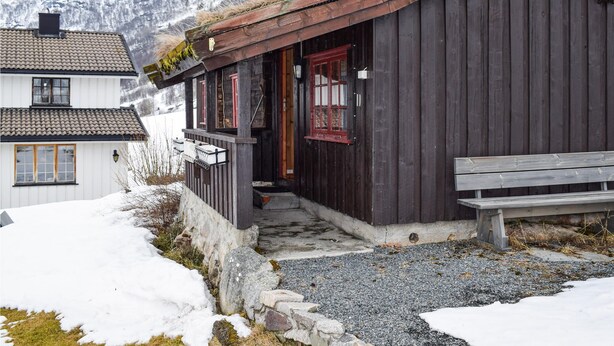 A rustic wooden building with a porch, a bench, and a view of snow-covered mountains in the background. - Nice home in Rauland with kitchen (Rauland)