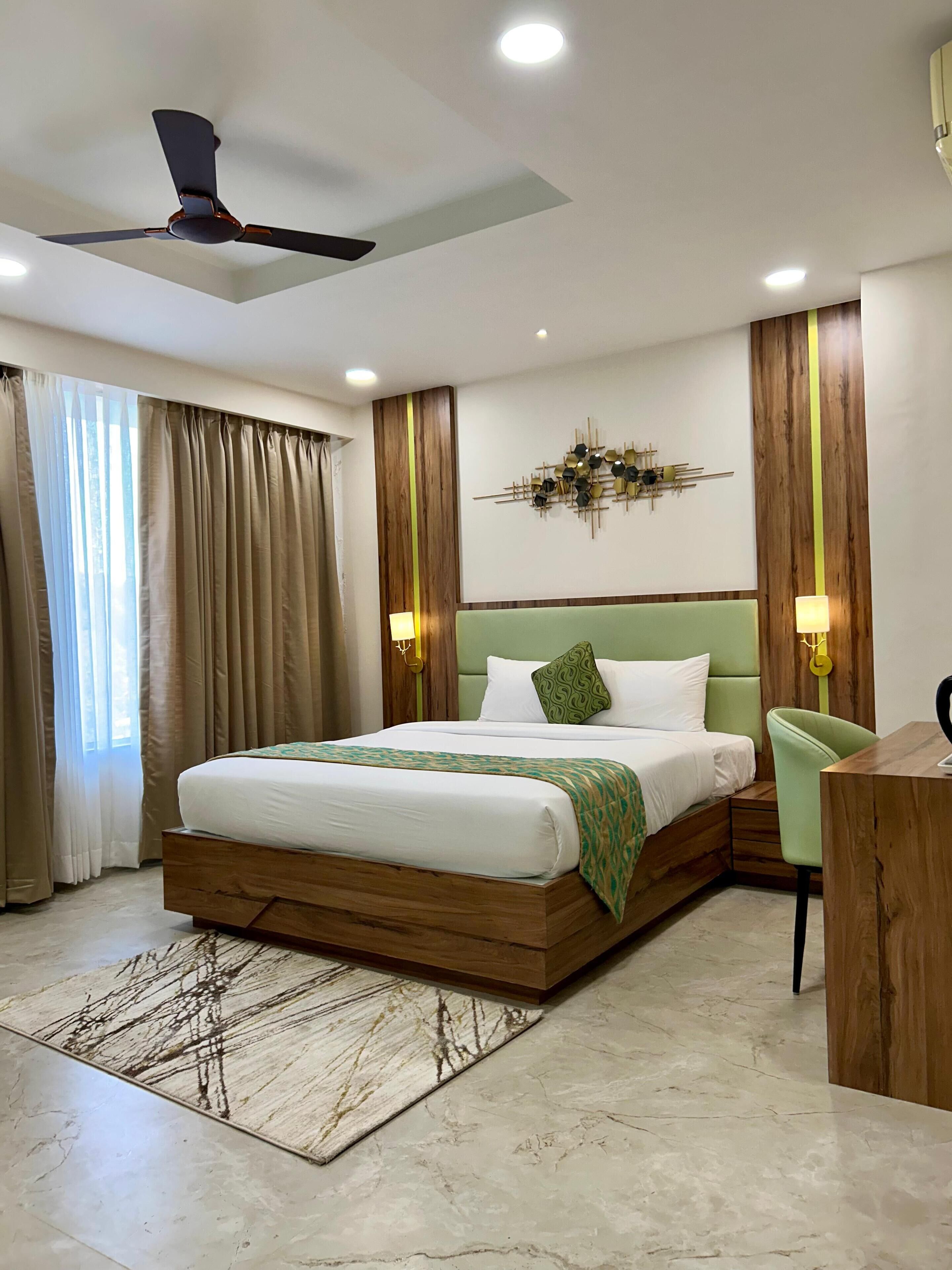 Un dormitorio moderno con estructura de cama de madera, cabecera tapizada en verde y un elemento decorativo sobre la cama.