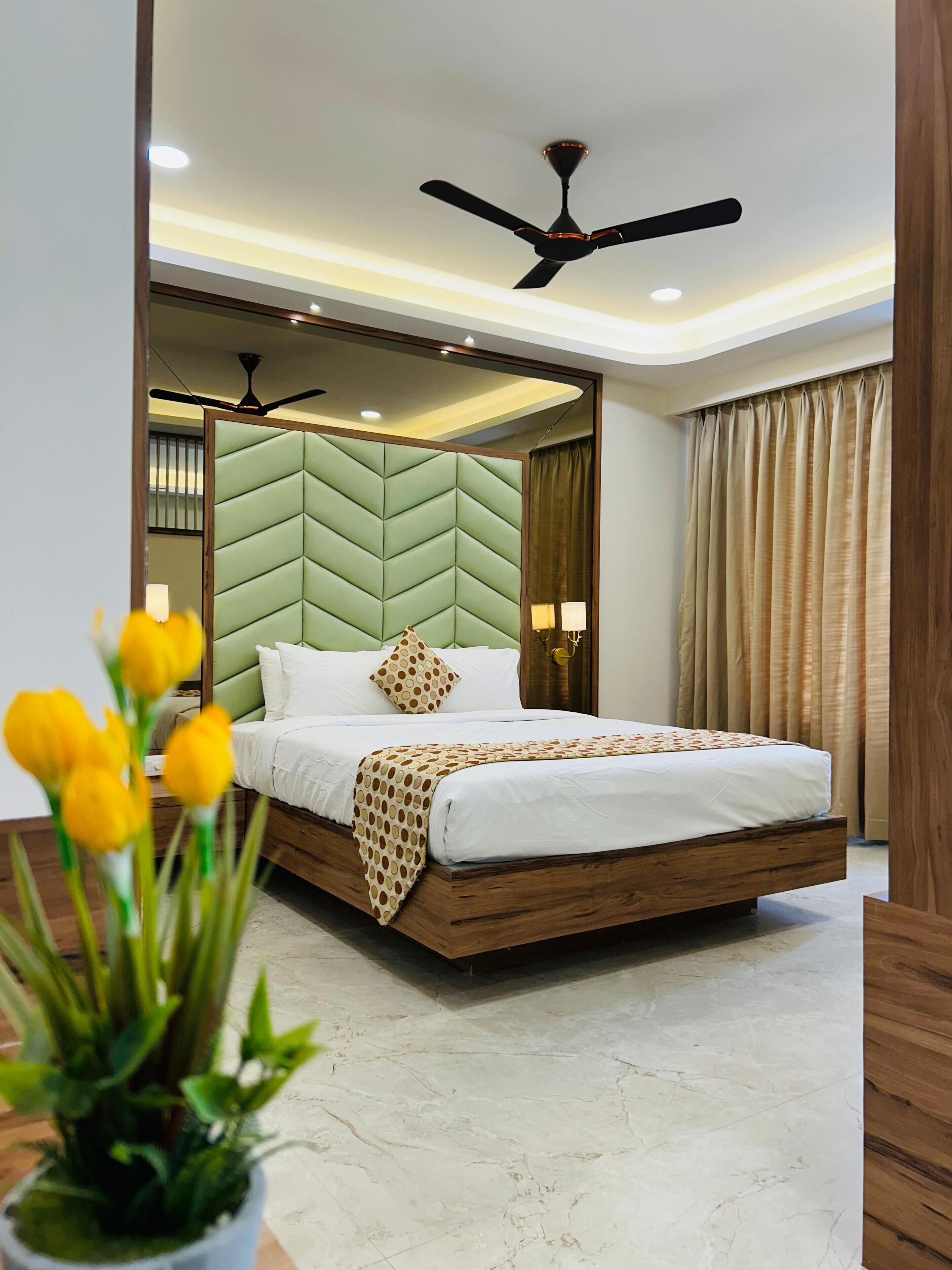 Un dormitorio moderno con una cama, ventilador de techo y una planta en maceta.