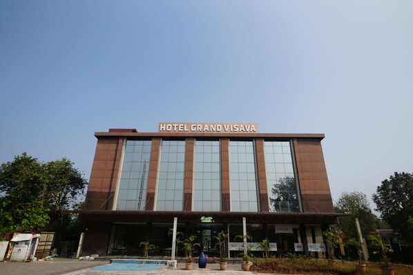 A modern building with a sign reading "HOTEL GRAND VISAVA" at the top. - Hotel Grand Visava (Mawal)