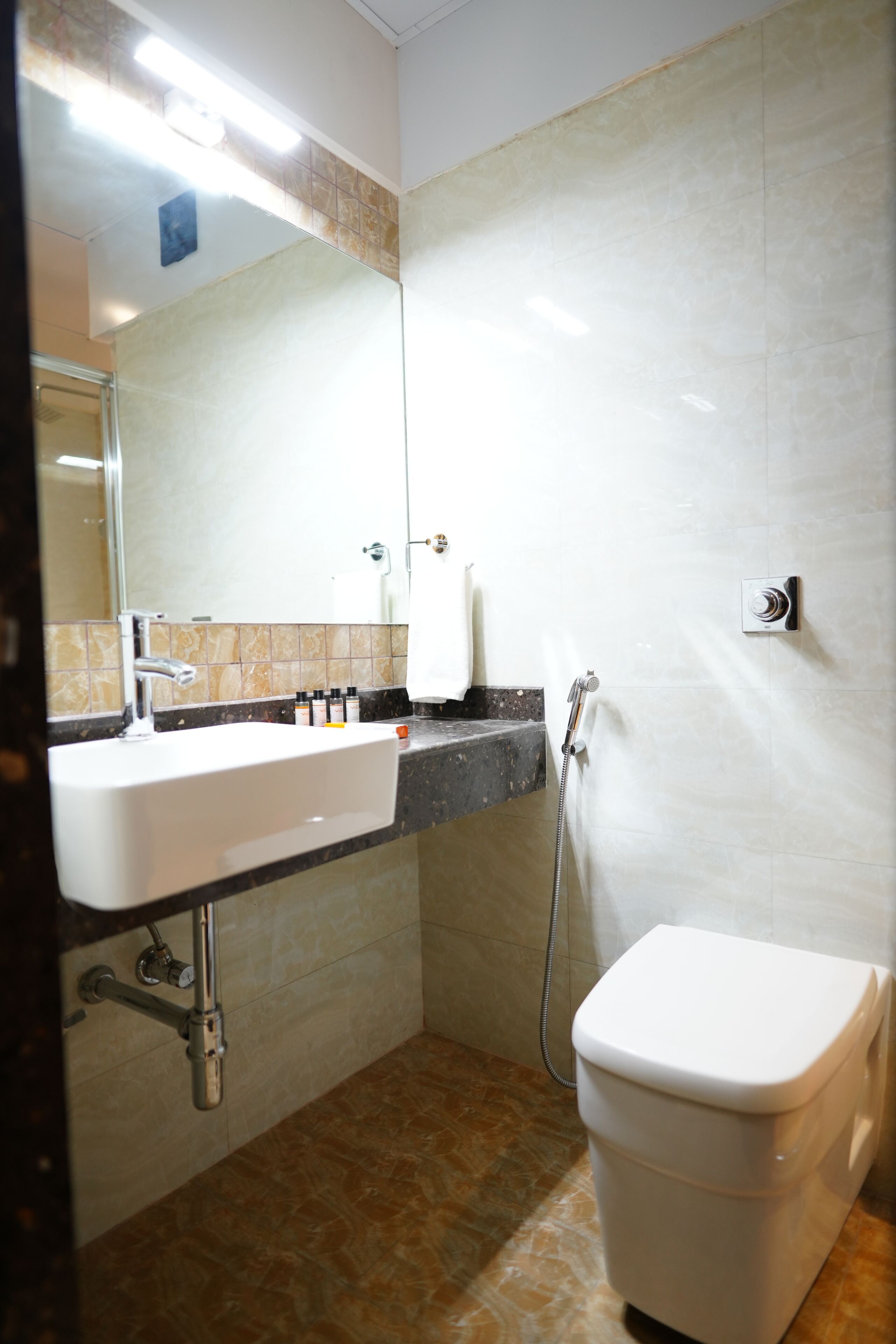 Un baño con lavamanos, espejo y retrete.