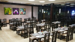 Un restaurante con varias mesas y sillas, dispuesto en un espacio amplio.