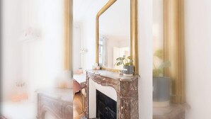 Une salle de bain avec un lavabo en marbre, un miroir et une plante en pot.