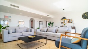 Ein modernes Wohnzimmer mit zwei Sofas, einem Couchtisch und einem blauen Sessel.