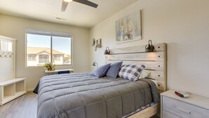 A bedroom with a bed, a nightstand, a desk, a window, and a ceiling fan. - Mesquite Vacation Rental Condo w/ Resort Amenities (Mesquite)