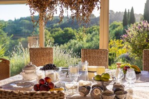 A table set with fruits, dairy, and glassware, overlooking a lush garden. - Villa Lorena a Vintage Family Villa (Capannori)
