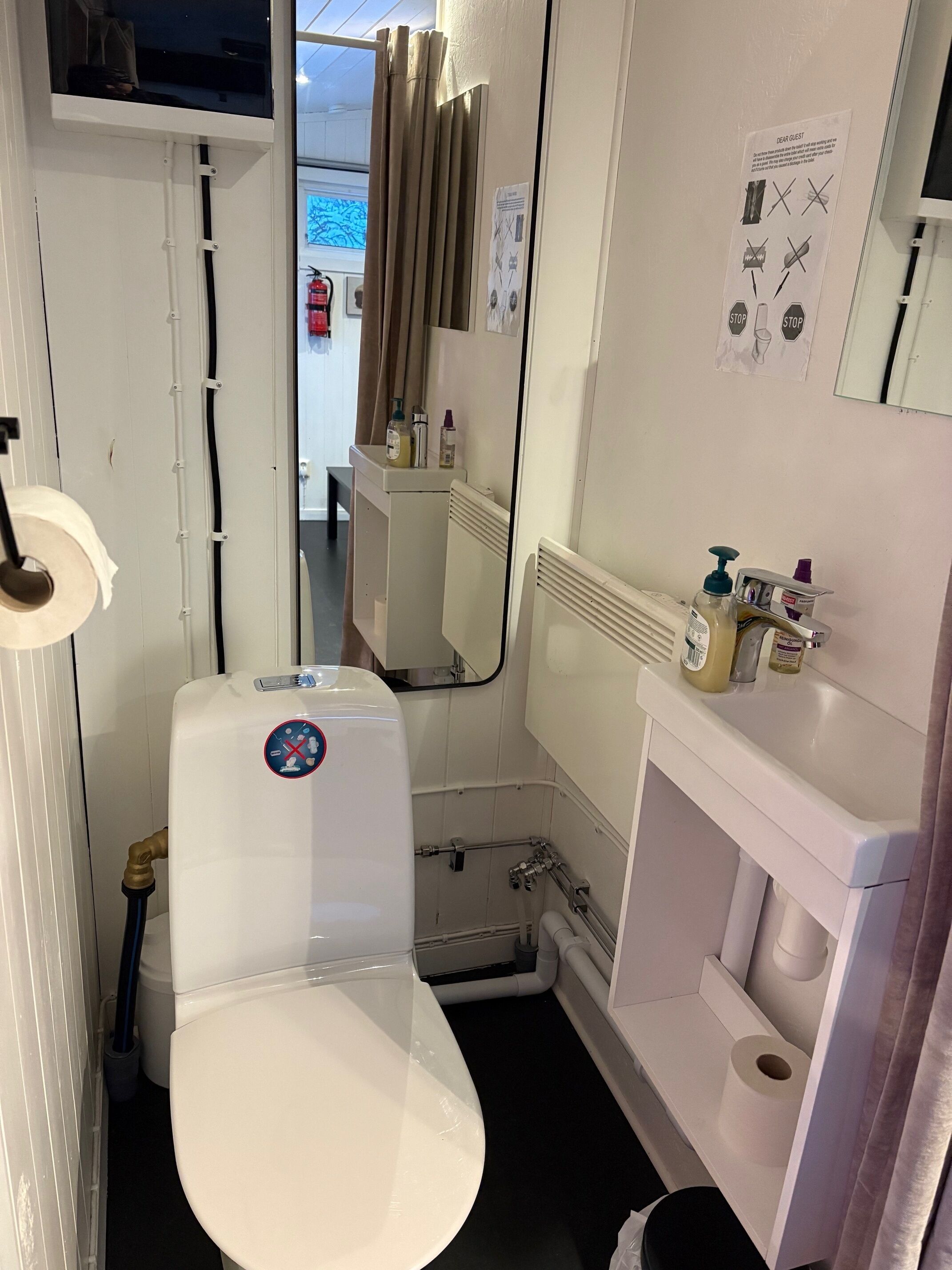 A compact bathroom with a toilet, a sink, and a shower area.