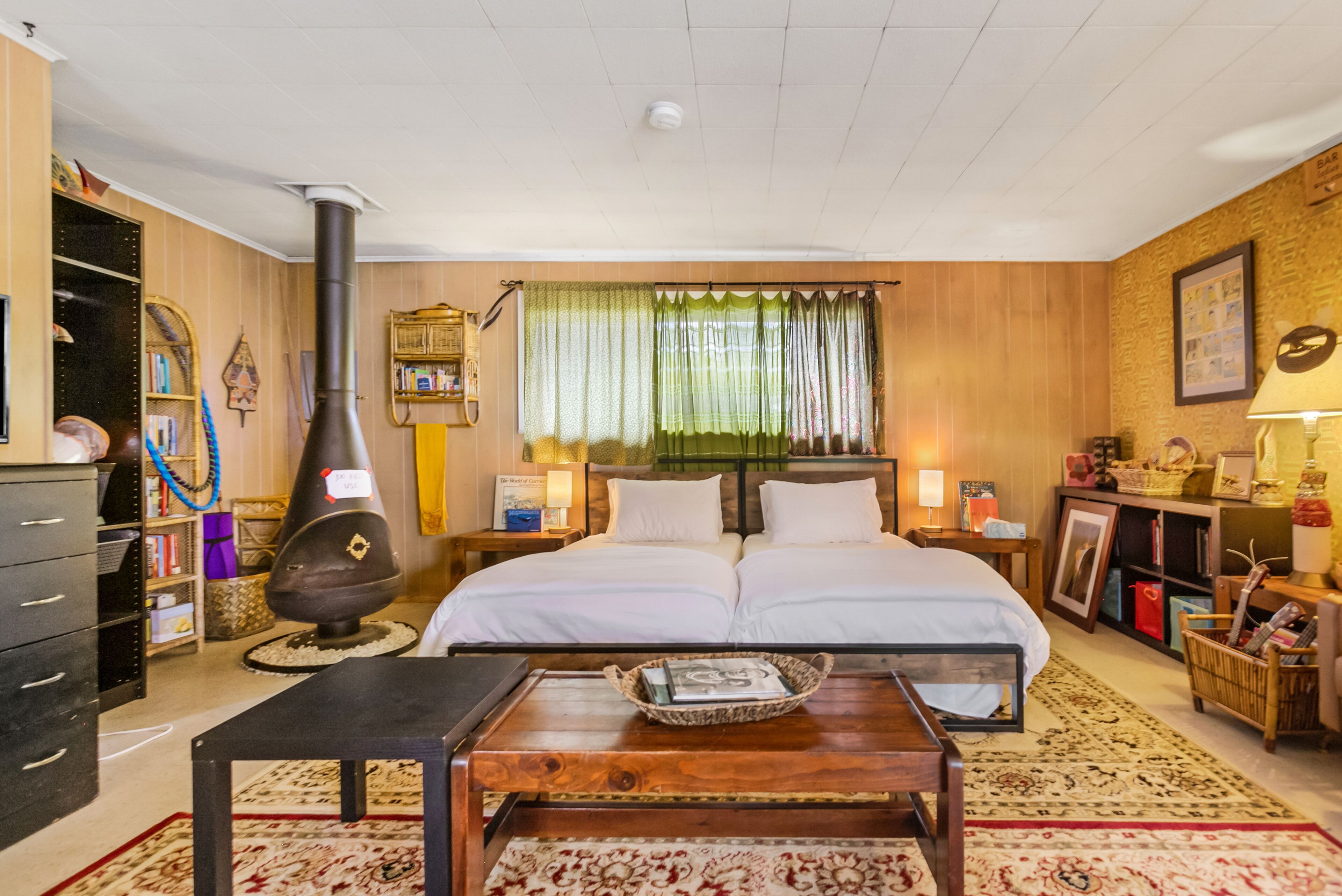 Een knus ingerichte kamer met een groot bed, een open haard, een boekenplank en een klein tafeltje met een dienblad.