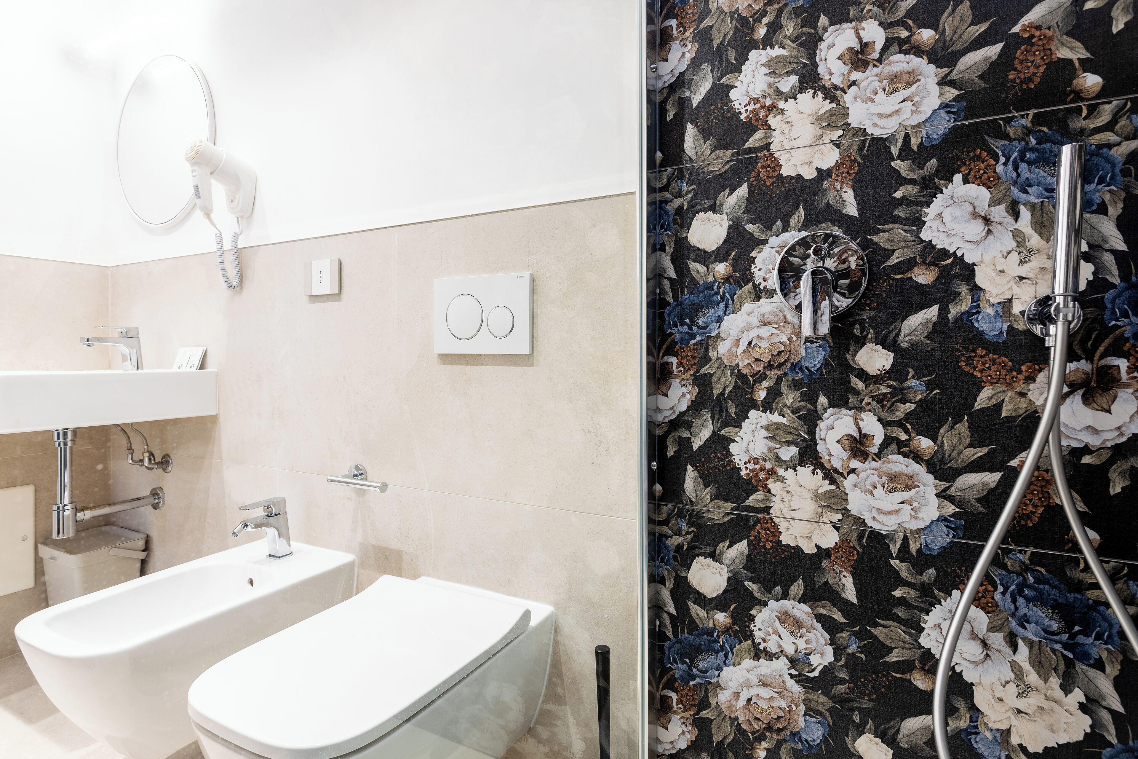 A bathroom with a bidet, a toilet, a sink, and a shower.
