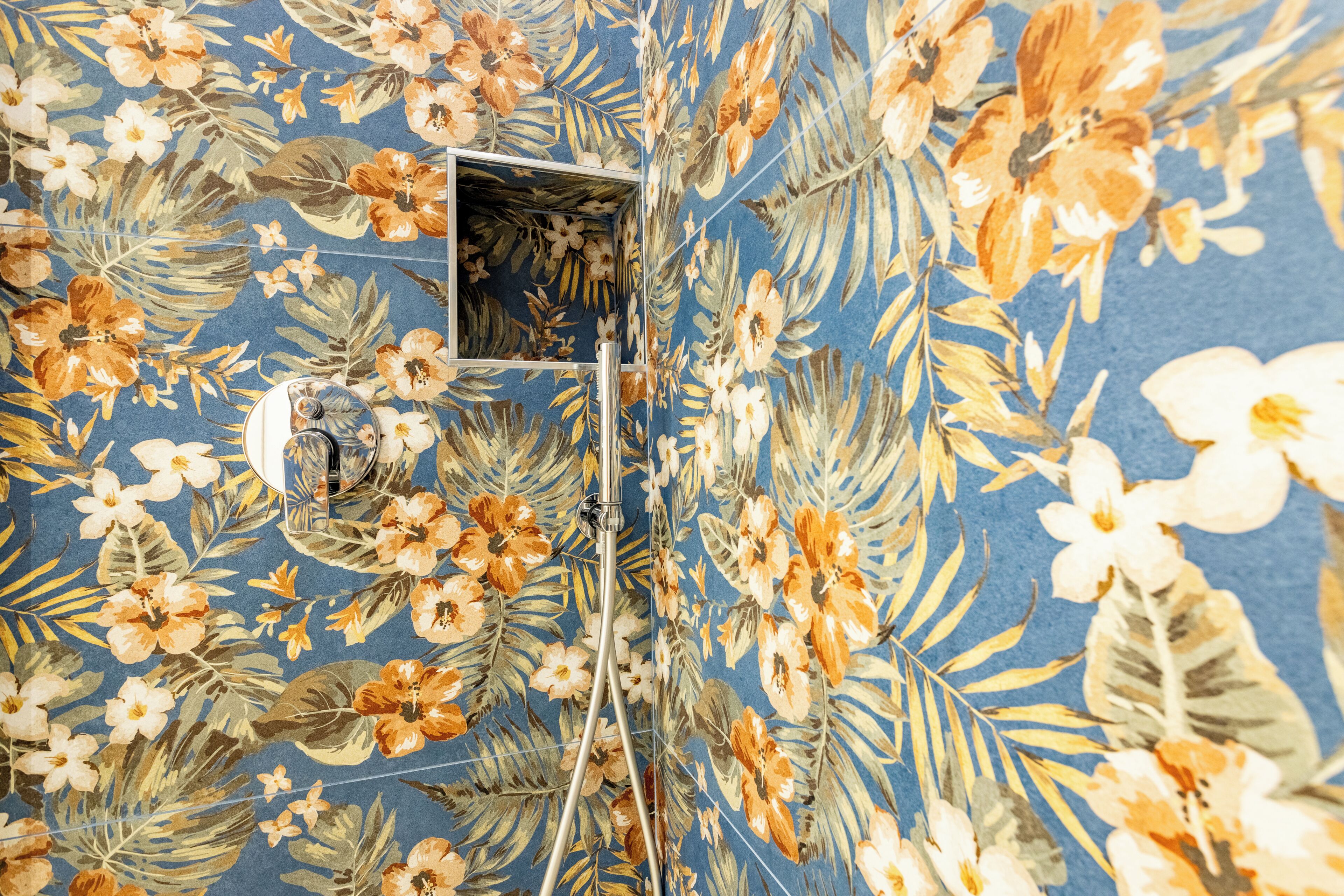 A room with a floral wallpaper pattern and a small window.