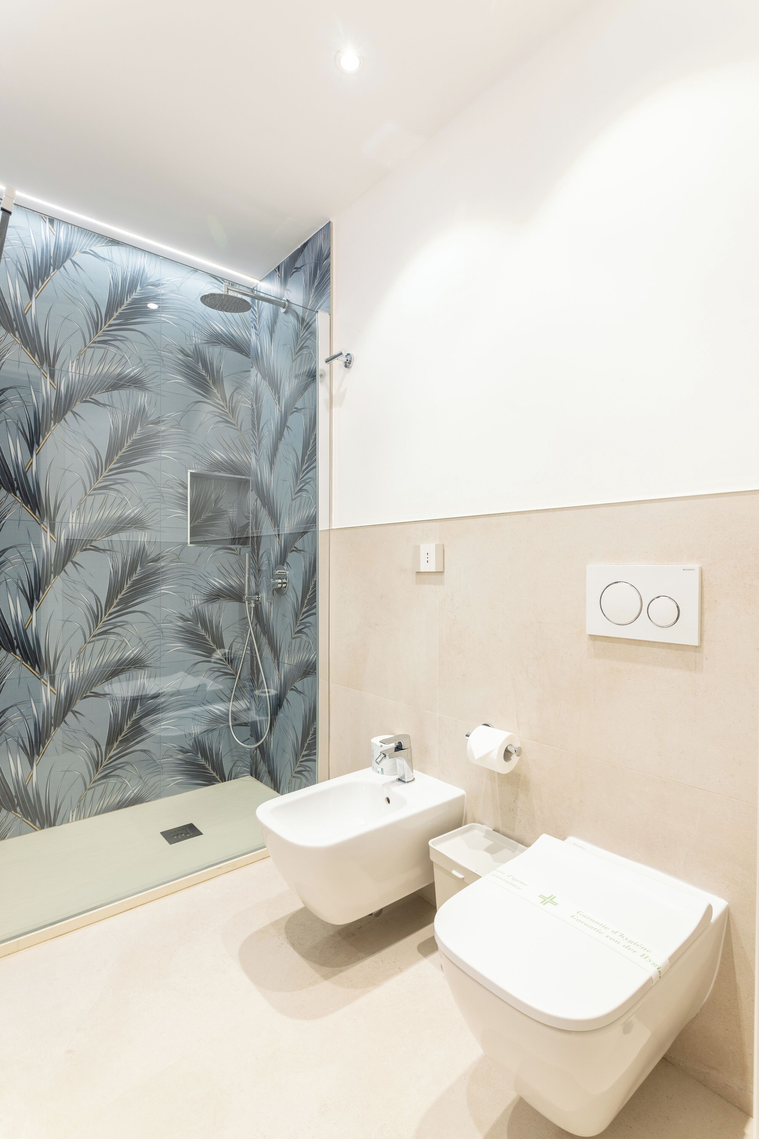 A modern bathroom with a shower, a sink, and a toilet.