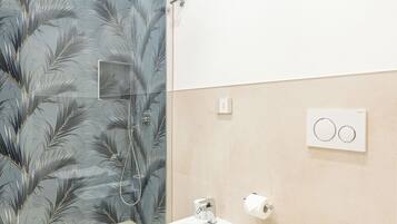 A modern bathroom with a shower, a sink, and a toilet.