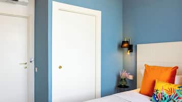Un dormitorio con una cama blanca, una pared azul y un techo de madera.