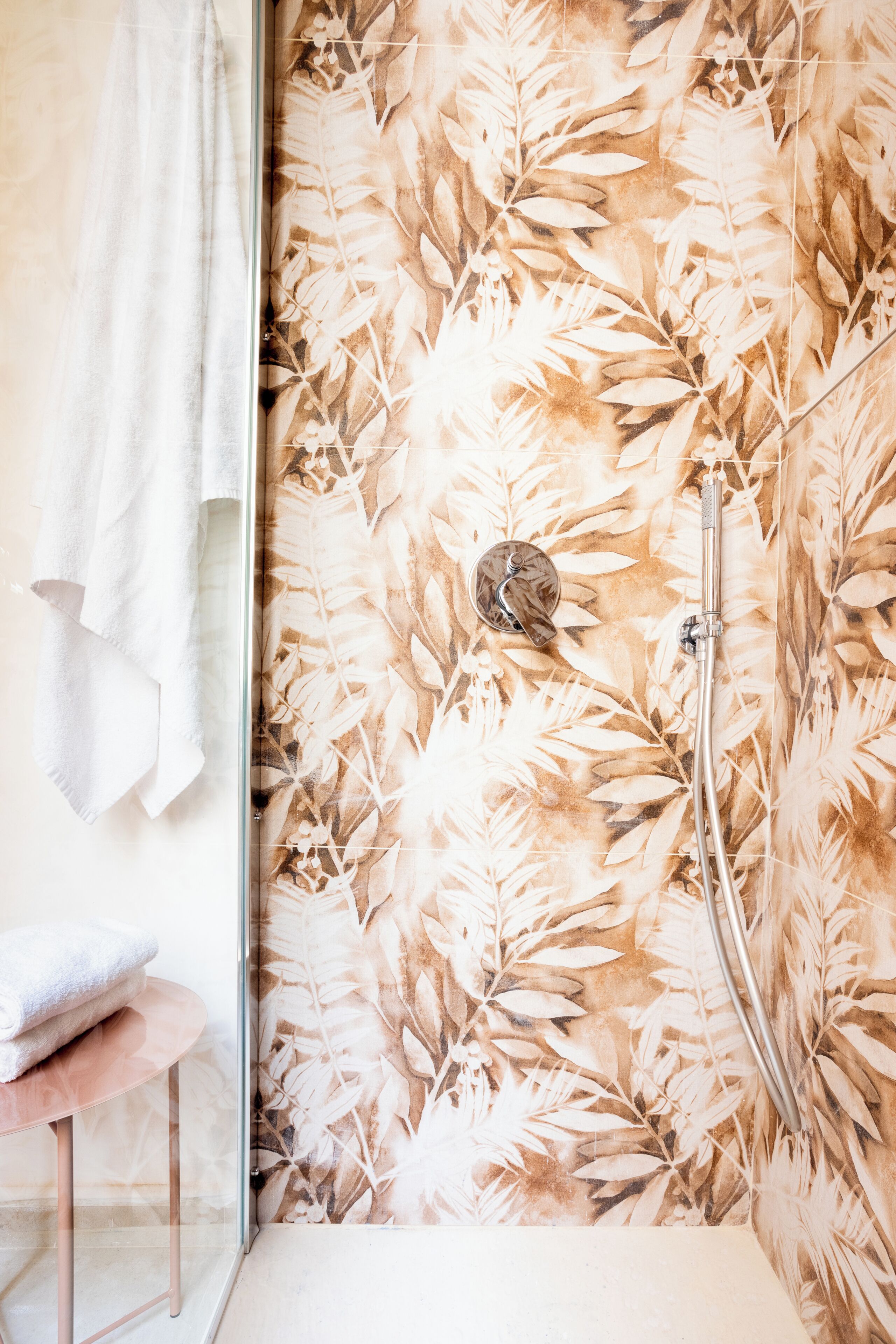 A bathroom with a shower, a towel rack, and a sink.
