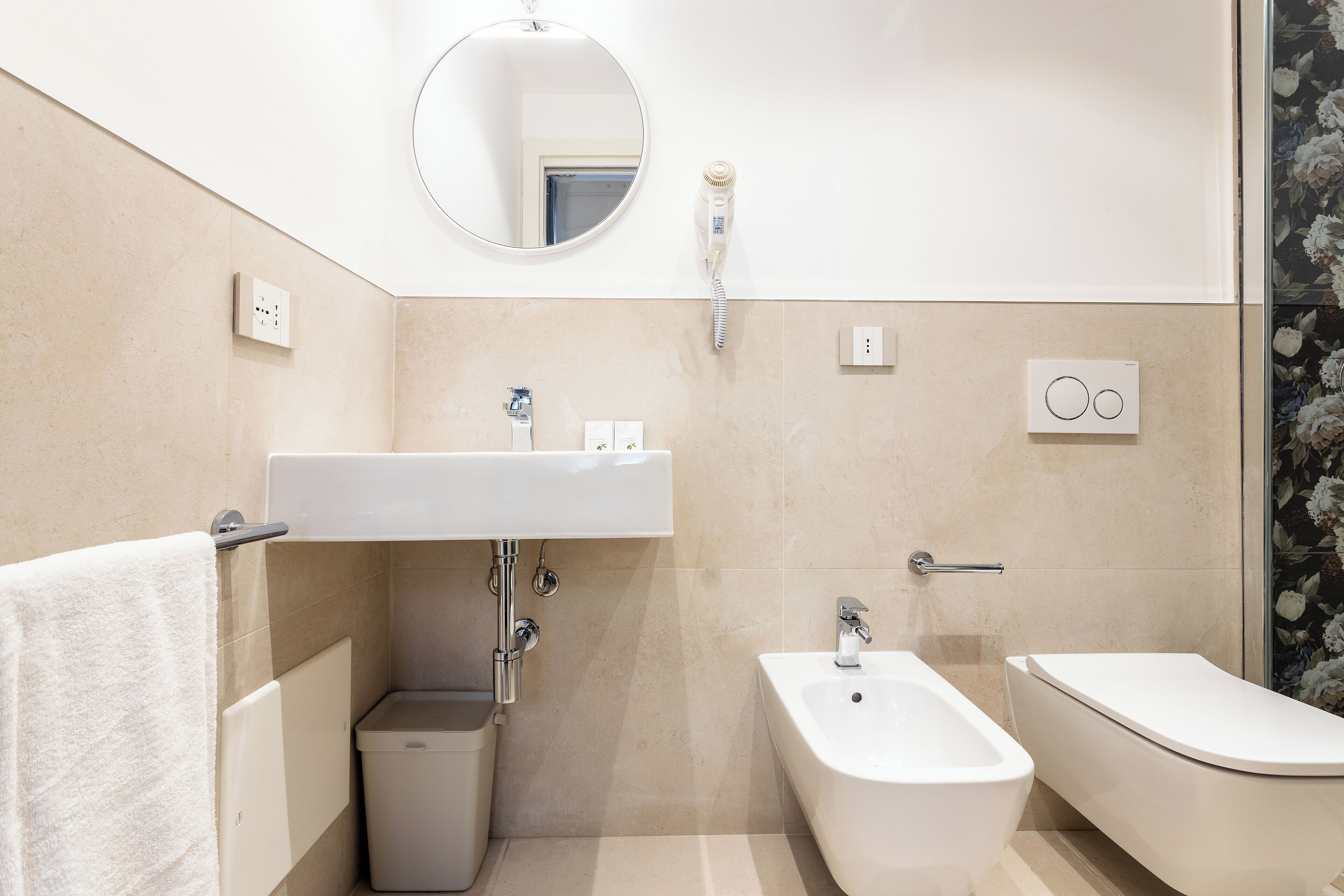 Ein modernes Badezimmer mit Waschbecken, Bidet, Toilette und Spiegel.