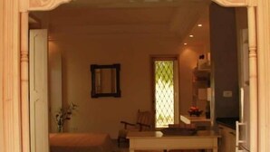 Un interior con comedor, sofá, una mesita y zona de cocina.