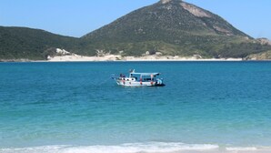 Un bateau sur des eaux calmes, avec une chaîne de montagnes en arrière-plan.