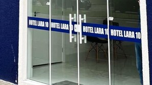 A hotel entrance with a blue facade, large glass doors, and a sign indicating "HOTEL LARA 10". - Hotel Lara 10 Curitiba (Curitiba)