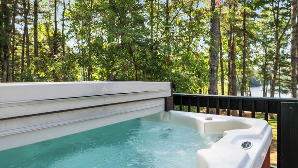 A hot tub with a view of a forested area.
