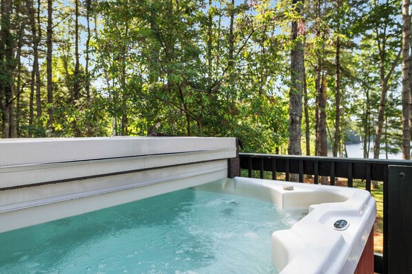 A hot tub with a view of a forested area.