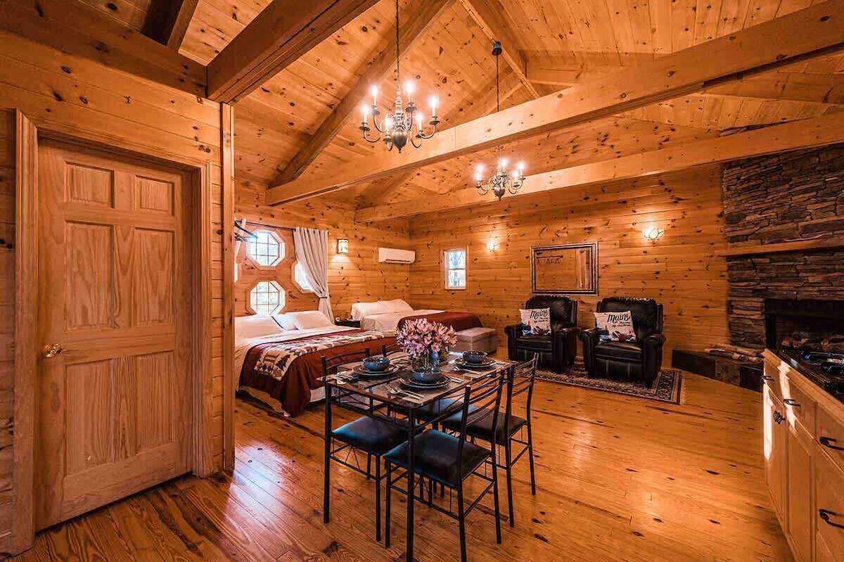 Enjoy the warmth of the cabin with a cozy sitting area, dining space, and plenty of room to relax in this inviting open layout.