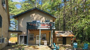 A two-story building with a balcony, a garage, and a small shed.