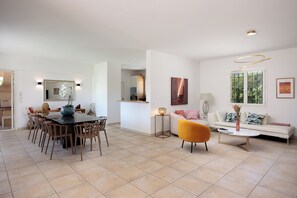 A modern living room with a dining area, a sofa, and a coffee table.