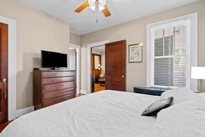 A bedroom with a bed, dresser, television, and a ceiling fan. - The O Place - Center of town and close to everything! (Galveston)
