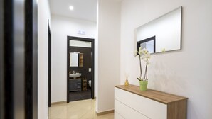 Une salle de bain moderne avec un lavabo, un miroir et une orchidée en pot.