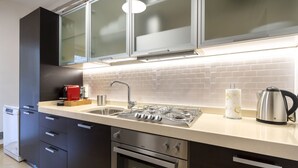 Une cuisine moderne équipée d’une cuisinière à gaz, d’un four et d’appareils électroménagers en acier inoxydable.