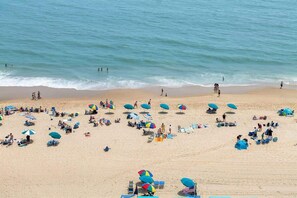 Een strand met vele parasols en stoelen, wat duidt op een ligging aan zee.