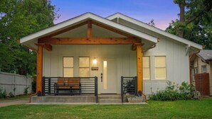 A single-story house with a front porch, a wooden beam structure, and a front door. - Native Inspired, Peaceful, & Practical Home. (Oklahoma City)