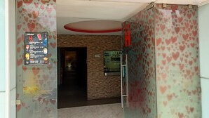 A hotel entrance with a glass door, a menu board on the left, and a wall with heart patterns. - Hotel Piet (Mexico City)