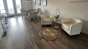 A spacious living room with a dining area, a white armchair, and a round coffee table. - Beautiful Townhouse ! (South Jordan)