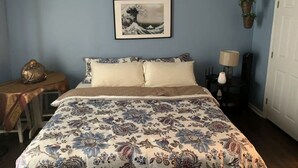 A bedroom with a bed, a nightstand, a lamp, and a framed picture on the wall. - The Redhawk Hideaway: Charming 2BR Condo near Miami Univ in Oxford! Book now! (Oxford)