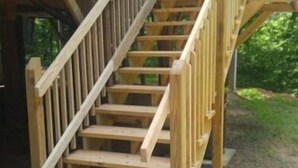 A wooden staircase leading to a porch with a railing. - Cabin, country setting, yet only minutes from everything! (Statesville)