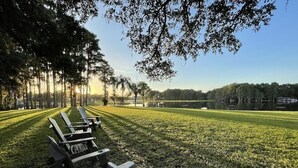 A park with rows of Adirondack chairs and a well-maintained lawn.
