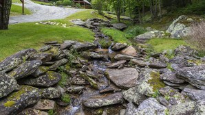 A rustic cabin with a wooden deck and a stone pathway leading to it. - Creekside Cabin on Private Acreage (Banner Elk)