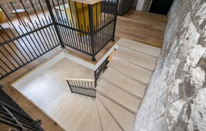 Staircase leads to a cozy seating area with a chair and table.
