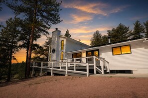 A modern two-story house with a white exterior, a visible chimney, and a covered outdoor staircase leading to a deck. - Circle J Ranch - 200+ acres of private Colorado experiences for family & friends (Lake George)